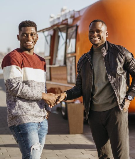 mid-shot-friends-shaking-hands-front-food-truck